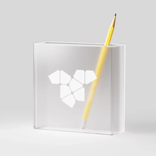 Frosted acrylic block with the TokenTek Einstein tile symbol and a yellow pencil
