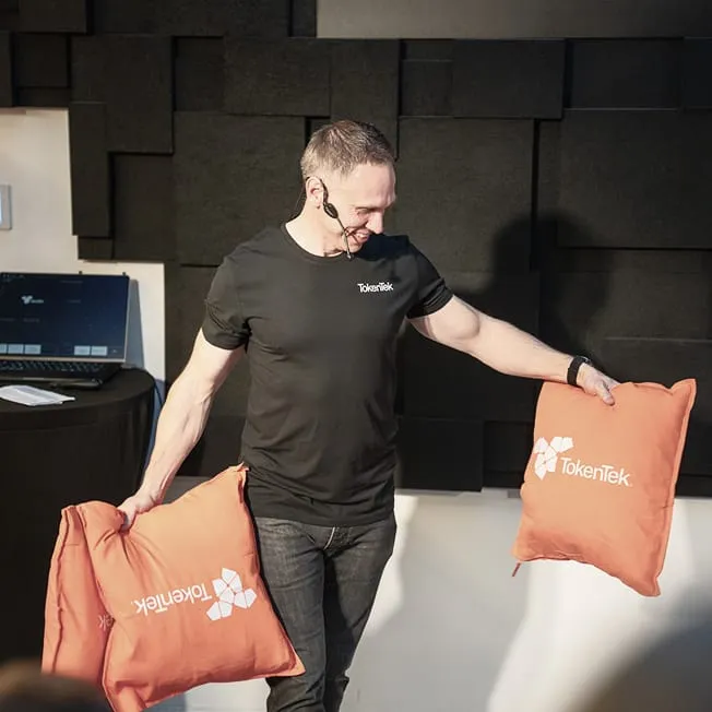 Johan Sanneblad on stage holding orange TokenTek pillows