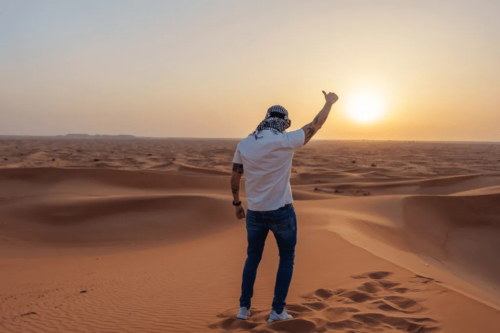 A TokenTek team member giving a thumbs up towards the desert sunset